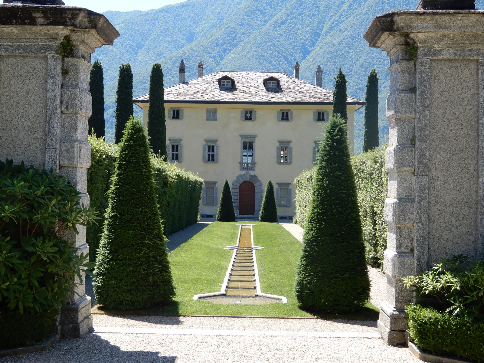 Villa Balbiano a Ossuccio: la facciata vista dal cancello d'ingresso, con il canale d'acqua tra i cipressi